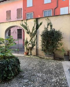 a courtyard of a building with a gate and plants at La petite Crema in Crema