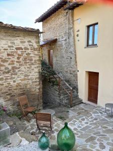 a patio with two green vases and a building at Borgo La Valle in Palazzo del Pero