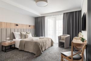 a bedroom with a bed and a desk and a chair at Rezydencja AMBRE in Łeba +148 photos