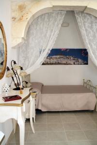 Un dormitorio con una cama y una mesa con escritorio. en Il Pumo Dorato, en Ostuni