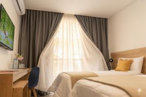 カンパーナにあるRM Campana Hotelのベッドが2つと窓があるホテルの部屋 +10枚の写真