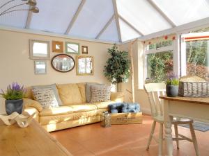 un soggiorno con un divano e un tavolo di The Old Winery Cottage a Dymock