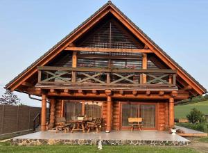 een grote blokhut met een tafel en stoelen bij Zrub Kriváň Drevená chata s výhľadom na Tatry in Závažná Poruba