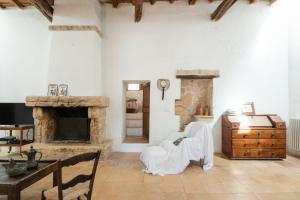 Una sala de estar con una silla y una chimenea. en New! Villa Can Gibert, en Sant Mateu d’Albarca