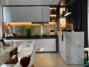 PrampuanにあるLombok Modern Nature Houseの白いキャビネットと白い椅子が備わるキッチン +18枚の写真