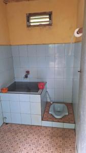 a bathroom with a toilet in a tiled room at Kalembang Krenata homestay in Rantepao