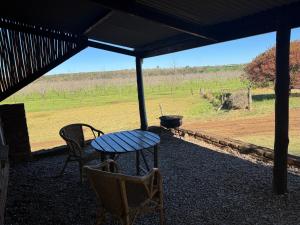 a table and chairs on a porch with a view of a field at The Pecan Cottage in Somerset East