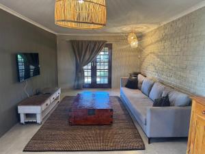 a living room with a couch and a table at The Pecan Cottage in Somerset East