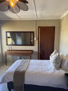 a bedroom with a large bed and a piano at The Pecan Cottage in Somerset East