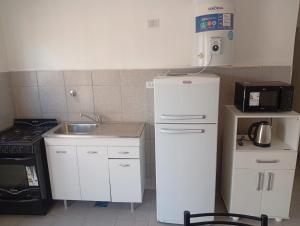 a small kitchen with a refrigerator and a sink at Departamento Magaquian in Chamical