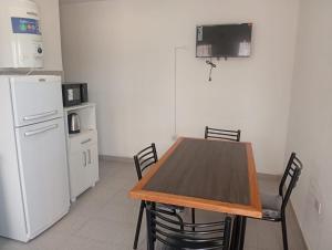 a kitchen with a wooden table and a white refrigerator at Departamento Magaquian in Chamical