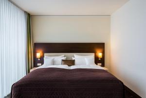 a bedroom with a large bed with white pillows at Hotel Esplanade Dortmund in Dortmund