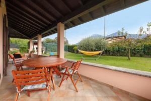 a patio with a table and chairs and a hammock at Casa Lago - Dongo in Dongo