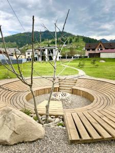 a wooden amphitheater with a tree in the middle at KalyNove апартаменти in Verkhniy Yasenov