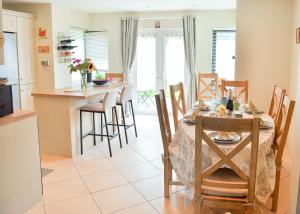 a kitchen and dining room with a table and chairs at Skellig Fuchsia Lodge Ballinskelligs by Trident Holiday Homes in Ballinskelligs