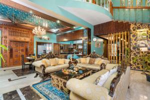 een woonkamer met meubilair en een kroonluchter bij Wooden Whispers Traditional Luxe Spacez Villa in Bangalore