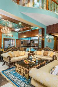 een grote woonkamer met banken en een tafel bij Wooden Whispers Traditional Luxe Spacez Villa in Bangalore +98 foto's