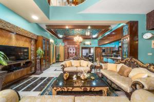 een woonkamer met een bank en een tv bij Wooden Whispers Traditional Luxe Spacez Villa in Bangalore