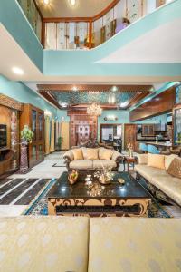 een woonkamer met een bank en een tafel bij Wooden Whispers Traditional Luxe Spacez Villa in Bangalore