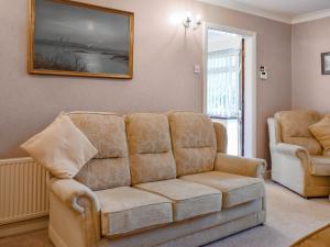 a living room with a couch and two chairs at Swallow Cottage - Uk49756 in Little Singleton