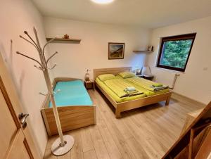 a bedroom with a bed and a tree in it at Triglav NP Apartment - above Bled in Zgornje Gorje