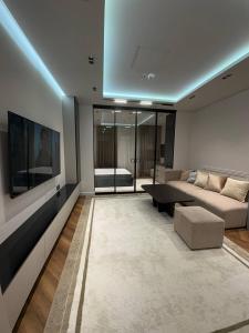 a living room with a couch and a table at Nest One Luxe, Элитные апартаменты с балконом и видом на фонтан Tashkent City Park 110 in Tashkent
