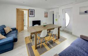 un soggiorno con tavolo in legno e divano blu di Stunning Apartment In Grand-Fort-Philippe a Grand-Fort-Philippe