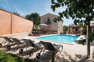 a group of chairs sitting next to a swimming pool at Villa Radetici in Radetići