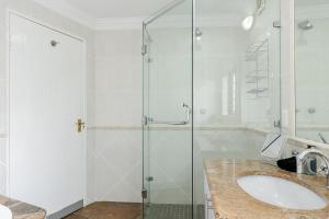 a bathroom with a sink and a glass shower at Matumi Golf Lodge in Nelspruit