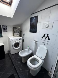 a bathroom with a toilet and a washing machine at La casa magica in Cuggiono +11 photos