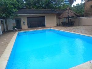 a large blue swimming pool next to a house at Lagos Residence - Luxury 4Bedroom Ikoyi in Lagos