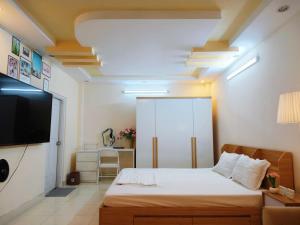 a bedroom with a bed and a flat screen tv at Góc Hải Phòng Drinks & Homestay Q4 in Ho Chi Minh City