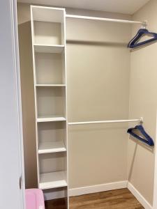 een kast met witte planken en blauwe hangers bij Charlottetown brand-new suite in Charlottetown