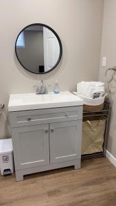 een badkamer met een witte wastafel en een spiegel bij Charlottetown brand-new suite in Charlottetown +12 foto's