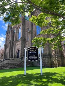 een bord in het gras voor een gebouw bij Charlottetown brand-new suite in Charlottetown
