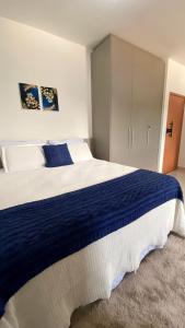 a bedroom with a large blue and white bed at 308-1 · Suíte Luxo Unievangélica/Ânima. 308 in Anápolis