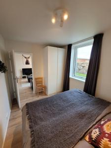 a bedroom with a large bed and a window at New, bright and spacious 1 bedroom apartment in Garðakauptún