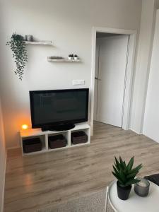a living room with a flat screen tv on a stand at New, bright and spacious 1 bedroom apartment in Garðakauptún