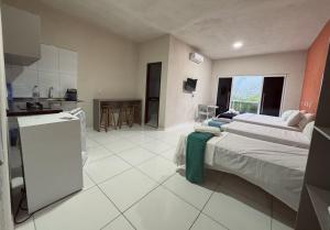 a large room with two beds and a kitchen at Bela Vista Japaratinga Flats e Temporada in Japaratinga