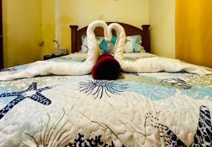 two swans sitting on top of a bed at Seaview Escape Tobago in Lambeau