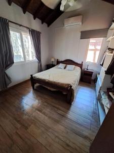 a bedroom with a large bed and two windows at Amura in Mar Azul