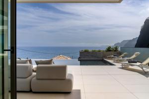 un soggiorno con vista sull'oceano di Villa Guindaste I Modern Villa with Sea View a Faial