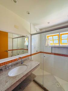 un bagno con lavandino e doccia in vetro di Casa Ponta de Areia a Corumbau