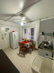 a kitchen with a table and a white refrigerator at Dubai in Balneário Camboriú
