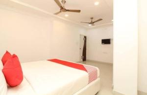 a bedroom with a white bed with a red pillow at Saba executive rooms and apartments in Hyderabad +3 photos