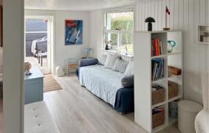 a living room with a couch and a book shelf at Nice Home In Slagelse With Wifi in Stillinge Strand