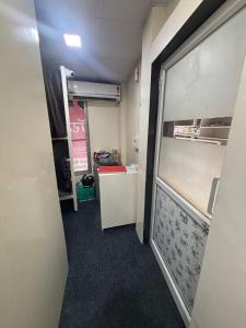 a corridor of a room with a door and a room with a unintention at Kapoor dormitory in Mumbai