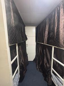 a small room with curtains and a closet at Kapoor dormitory in Mumbai