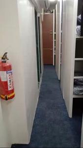 a hallway with a fire extinguisher on the wall at Kapoor dormitory in Mumbai