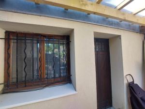 a window with a iron fence on the side of a building at Chambre-coin repas, sous terrasse, Proche gare in Franconville